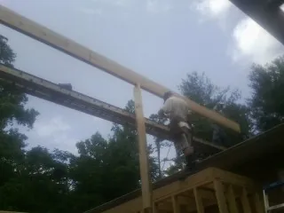 Carpenter setting a ridge beam over a new addition frame — Ice Dam Removal by Roofing Brothers in Bryce